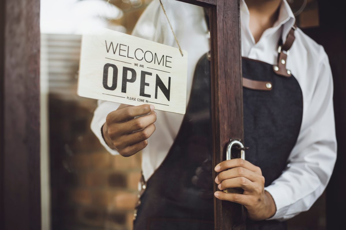 Retail store owning turning around a welcome sign