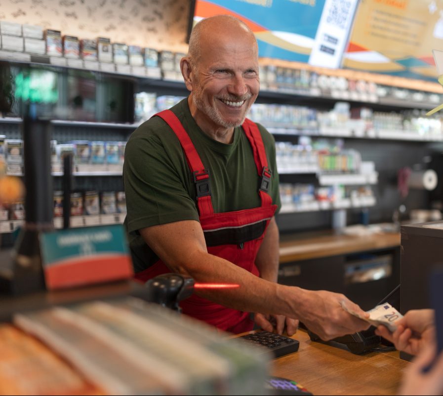 Employee taking cash payment from costumer in gas station, close-up