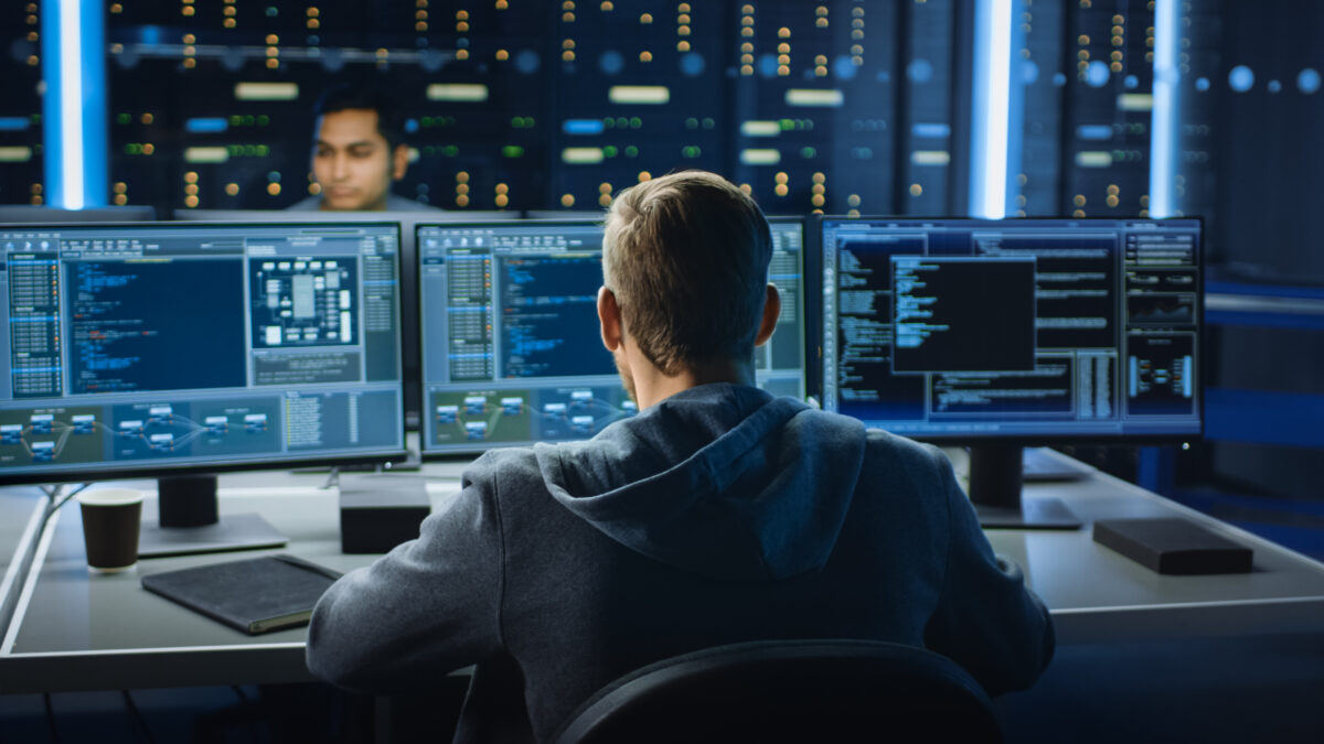 IT Specialist Works on Computer with Screens Showing data